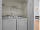 Bright laundry room with front-loading washer and dryer, and wire shelving for organization at 613 Flaherty Ave, Wake Forest, NC 27587