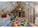 This attic space has exposed beams and rafters, with a colorful geometric rug at 690 Hawthorne Pl, Creedmoor, NC 27522