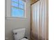 Bathroom showcasing a toilet, shower curtain, window, and natural light at 690 Hawthorne Pl, Creedmoor, NC 27522