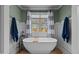 Elegant bathroom featuring a freestanding soaking tub with modern fixtures and wainscoting for a spa-like experience at 690 Hawthorne Pl, Creedmoor, NC 27522