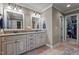 Bathroom featuring dual vanities with granite countertops, decorative mirrors, and tile flooring at 690 Hawthorne Pl, Creedmoor, NC 27522