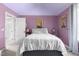 Charming bedroom with lavender walls, decorative artwork, and plush bedding at 690 Hawthorne Pl, Creedmoor, NC 27522