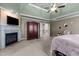 Cozy main bedroom featuring a fireplace, ceiling fan, and access to upper hall, with neutral carpet at 690 Hawthorne Pl, Creedmoor, NC 27522