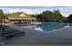 Large community pool with plenty of lounge chairs, trees, and a building that offers covered seating at 690 Hawthorne Pl, Creedmoor, NC 27522