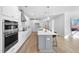 Modern kitchen featuring white cabinets, stainless steel appliances, and a large center island with seating at 720 Shell Bank Ct, Cary, NC 27519