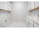 Clean laundry room with white cabinets and utility sink at 720 Shell Bank Ct, Cary, NC 27519