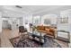 Open-concept living room featuring hardwood floors, a modern sofa, and ample natural light at 720 Shell Bank Ct, Cary, NC 27519