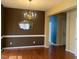 Traditional dining room with dark brown walls, wood floors, and a gold chandelier at 7710 Astoria Pl, Raleigh, NC 27612
