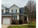 Two-story brick and siding home with an attached garage and a beautifully landscaped yard at 7710 Astoria Pl, Raleigh, NC 27612