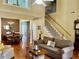 Open-concept living room with fireplace, hardwood floors, and staircase at 7710 Astoria Pl, Raleigh, NC 27612