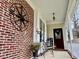 Inviting covered porch features brick accents, seating, and decorative details at 7710 Astoria Pl, Raleigh, NC 27612