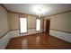 Charming dining room with classic wallpaper, hardwood floors, chandelier, and natural light from two windows at 8510 Polaris Dr, Bahama, NC 27503