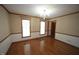 Dining room with wood floors, neutral wallpaper, chair railing, chandelier, and two windows at 8510 Polaris Dr, Bahama, NC 27503