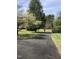 Long, paved driveway leading to a beautiful home surrounded by mature trees and lush greenery at 8510 Polaris Dr, Bahama, NC 27503
