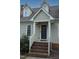 Front entrance of home with brick steps, white railing and posts, and classic black front door at 8510 Polaris Dr, Bahama, NC 27503