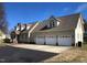 Rear exterior view of a two-story house with a three-car garage and paved driveway at 8510 Polaris Dr, Bahama, NC 27503
