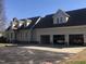 A tan home featuring a driveway and a three-car garage with classic cars visible at 8510 Polaris Dr, Bahama, NC 27503