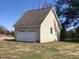 Detached garage with a white door and light-colored siding, set against a clear blue sky at 8510 Polaris Dr, Bahama, NC 27503