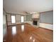 Spacious living room with hardwood floors, stone fireplace, ceiling fan, and large windows at 8510 Polaris Dr, Bahama, NC 27503