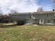 Rear view of a house featuring a covered car port and a well-maintained lawn at 8510 Polaris Dr, Bahama, NC 27503