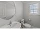 Clean bathroom features a large mirror, toilet, and window with natural light at 8712 New River Cir, Raleigh, NC 27603