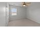 Well-lit bedroom featuring neutral carpet, a ceiling fan, and a view from the window at 8712 New River Cir, Raleigh, NC 27603