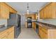 Spacious kitchen features wooden cabinets, a black refrigerator, and neutral flooring at 8712 New River Cir, Raleigh, NC 27603