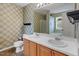 Bathroom featuring a double vanity, mirrors, and coordinated wallpaper at 904 Churchill Glen Blvd, Knightdale, NC 27545