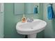 Cozy powder room featuring a white pedestal sink, faucet, mirror and a blue hand towel at 904 Churchill Glen Blvd, Knightdale, NC 27545