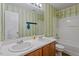 Well-lit bathroom with double vanity, large mirror, and shower-tub combination at 904 Churchill Glen Blvd, Knightdale, NC 27545