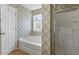 Bathroom with a soaking tub, separate shower, and decorative wallpaper at 904 Churchill Glen Blvd, Knightdale, NC 27545
