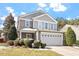 Two-story home showcasing a front-facing two-car garage and a landscaped front yard at 904 Churchill Glen Blvd, Knightdale, NC 27545