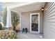 A cozy front porch featuring neutral siding, stylish pillars and a glass front door at 904 Churchill Glen Blvd, Knightdale, NC 27545
