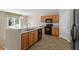 Bright kitchen with wooden cabinetry, black appliances, and granite countertops overlooking green backyard at 904 Churchill Glen Blvd, Knightdale, NC 27545