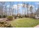 Large backyard with lush green grass, mature trees, and landscaping, offering a private oasis at 907 Vintage Hill Pkwy, Durham, NC 27712