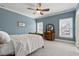 Cozy bedroom featuring a ceiling fan, gray carpet, and natural light from the windows at 907 Vintage Hill Pkwy, Durham, NC 27712
