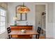 Cozy dining area featuring a wooden table, chairs, and a unique dragonfly-themed pendant light fixture at 907 Vintage Hill Pkwy, Durham, NC 27712