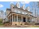 Stunning two-story home with a spacious wrap-around porch, stone foundation, and blue accent shutters at 907 Vintage Hill Pkwy, Durham, NC 27712