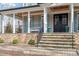 Inviting front porch with stone base, columns, seating, and a view of the double door entrance at 907 Vintage Hill Pkwy, Durham, NC 27712