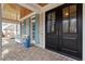 Welcoming front porch featuring stone flooring, columns, seating, and a beautiful double door entrance at 907 Vintage Hill Pkwy, Durham, NC 27712