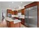 Gourmet kitchen with a stainless steel refrigerator, custom cabinets, and a large island cooktop at 907 Vintage Hill Pkwy, Durham, NC 27712
