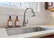 Close up of a kitchen sink with a marble countertop, a stainless steel faucet, and white subway tiles at 907 Vintage Hill Pkwy, Durham, NC 27712