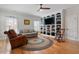 Comfortable living room with a custom built-in bookshelf, wood floors, and natural lighting at 907 Vintage Hill Pkwy, Durham, NC 27712
