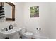 Compact powder room featuring a sink, toilet, and a decorative wood-framed mirror at 907 Vintage Hill Pkwy, Durham, NC 27712