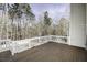 Wooden deck with white railing, offering a serene view of the surrounding trees at 9244 Palm Bay Cir, Raleigh, NC 27617