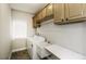 Functional laundry room with washer, dryer, sink, and overhead cabinets at 9244 Palm Bay Cir, Raleigh, NC 27617