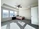 Spacious bedroom featuring a ceiling fan, three large windows, and neutral-colored walls and carpet at 103 Ransomwood Dr, Apex, NC 27539