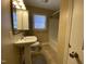 Modest bathroom featuring a pedestal sink, toilet, and shower/tub combination at 103 W Thorndale Dr, Oxford, NC 27565