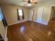 Bedroom with hardwood floors, ceiling fan, and large window with dark curtains, adjoining bath at 103 W Thorndale Dr, Oxford, NC 27565