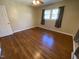 Bedroom featuring hardwood floors, a ceiling fan and a window with dark gray curtains at 103 W Thorndale Dr, Oxford, NC 27565